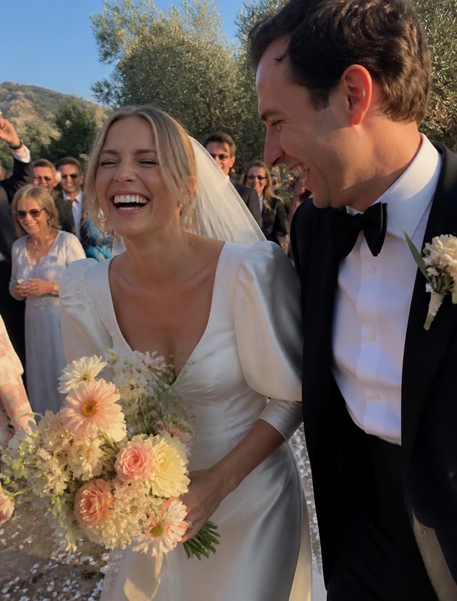 The couple laughing as guests cheer